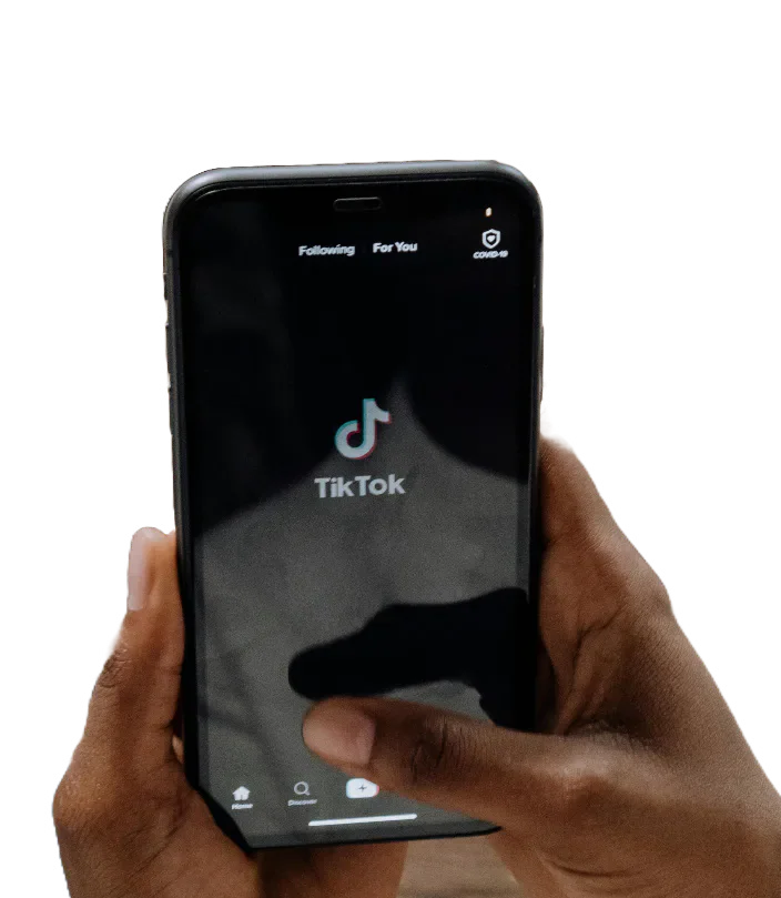 A hand holding a phone displaying TikTok