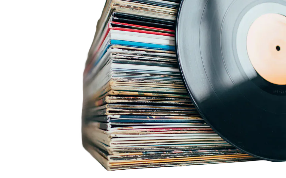 A vinyl record beside a stack of record sleeves