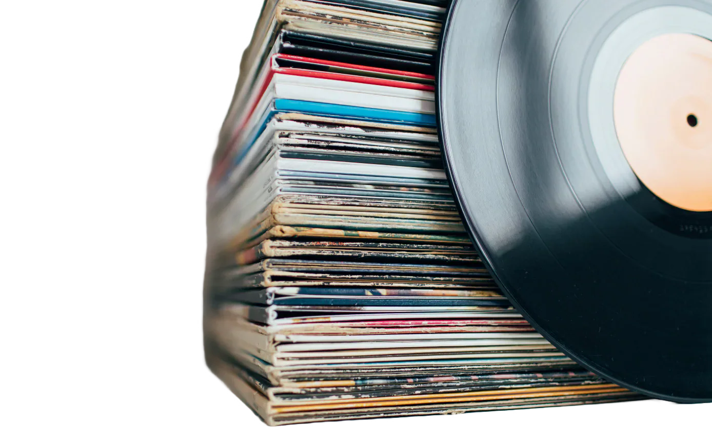 A vinyl record beside a stack of record sleeves