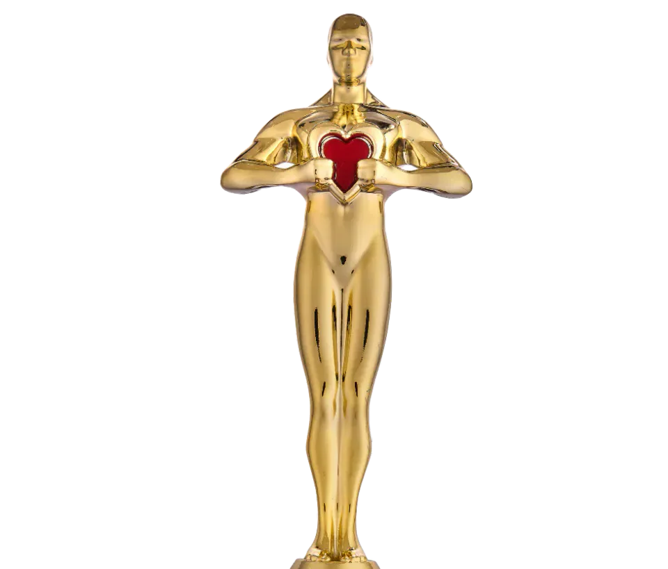 A gold award statuette holding a red heart
