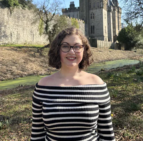 The editor pictured outdoors in front of a castle.