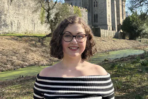The editor pictured outdoors in front of a castle.