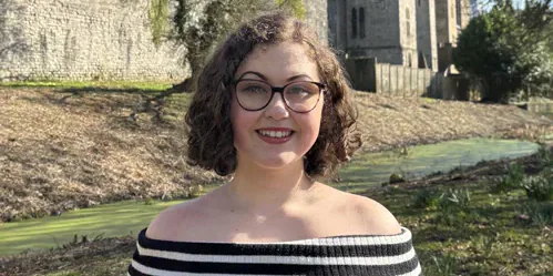 The editor pictured outdoors in front of a castle.