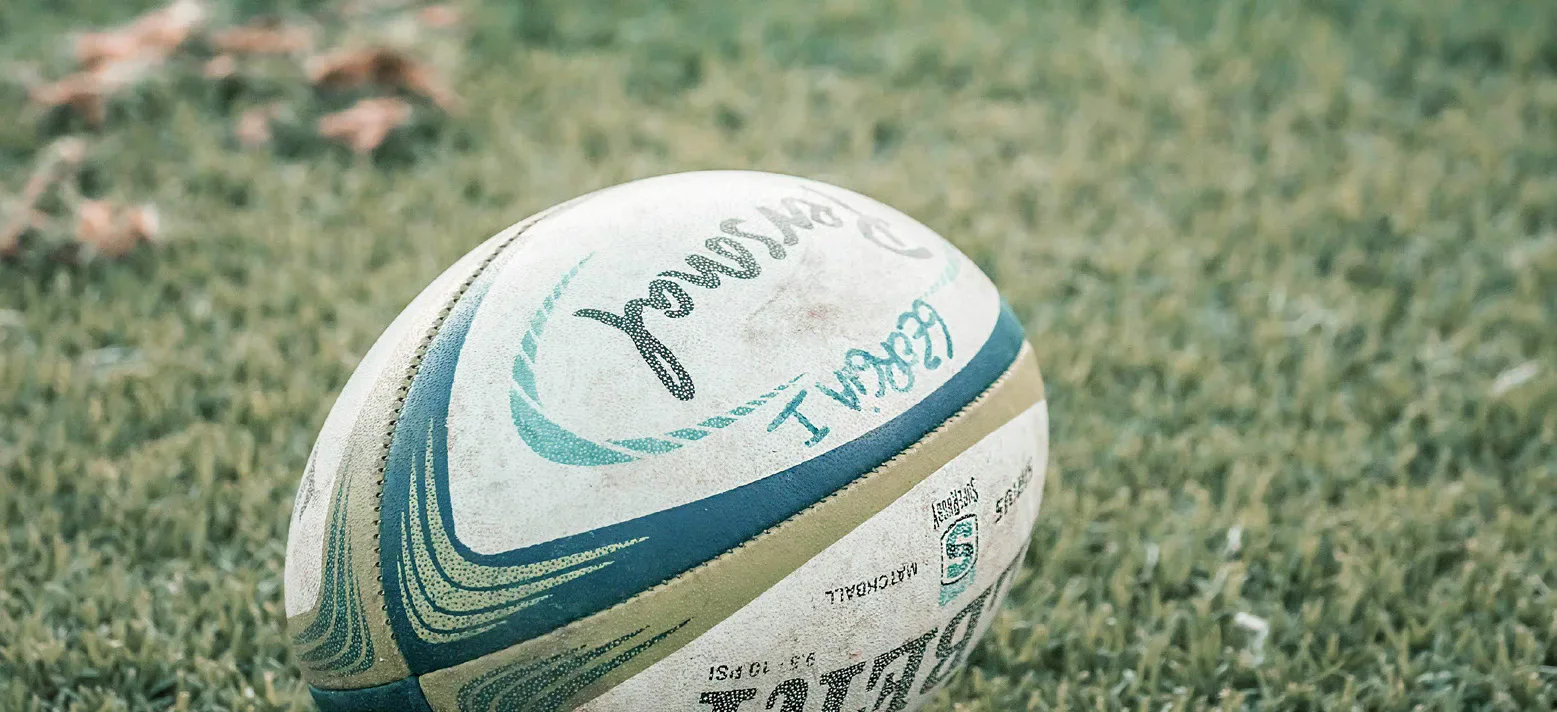 A rugby ball resting on grass.