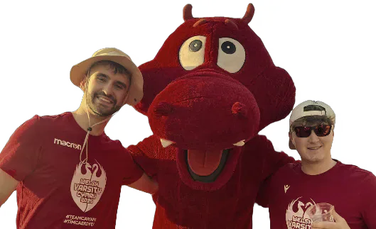 Two Cardiff supporters standing beside the red dragon mascot.