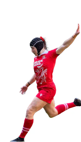 A Cardiff women's rugby player in red kit kicking.