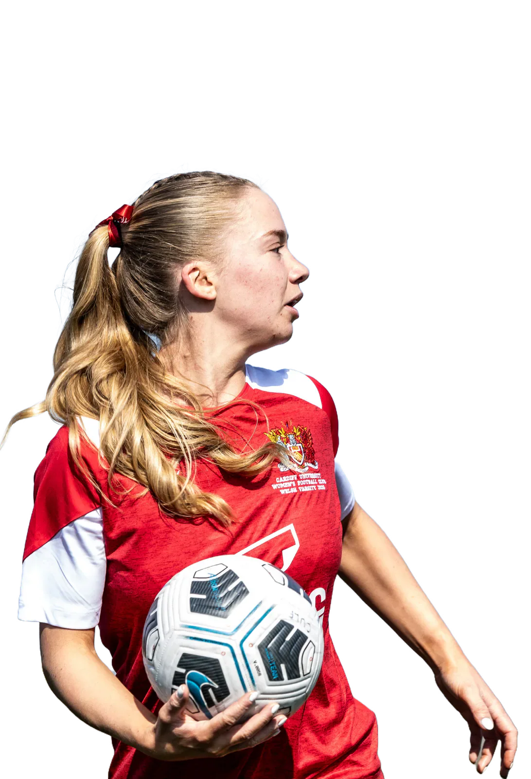 A Cardiff women's football player in a red and white shirt holds a football.