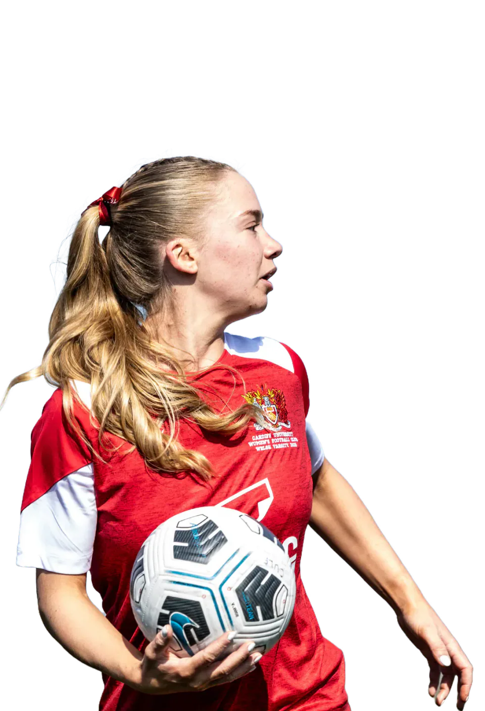 A Cardiff women's football player in a red and white shirt holds a football.
