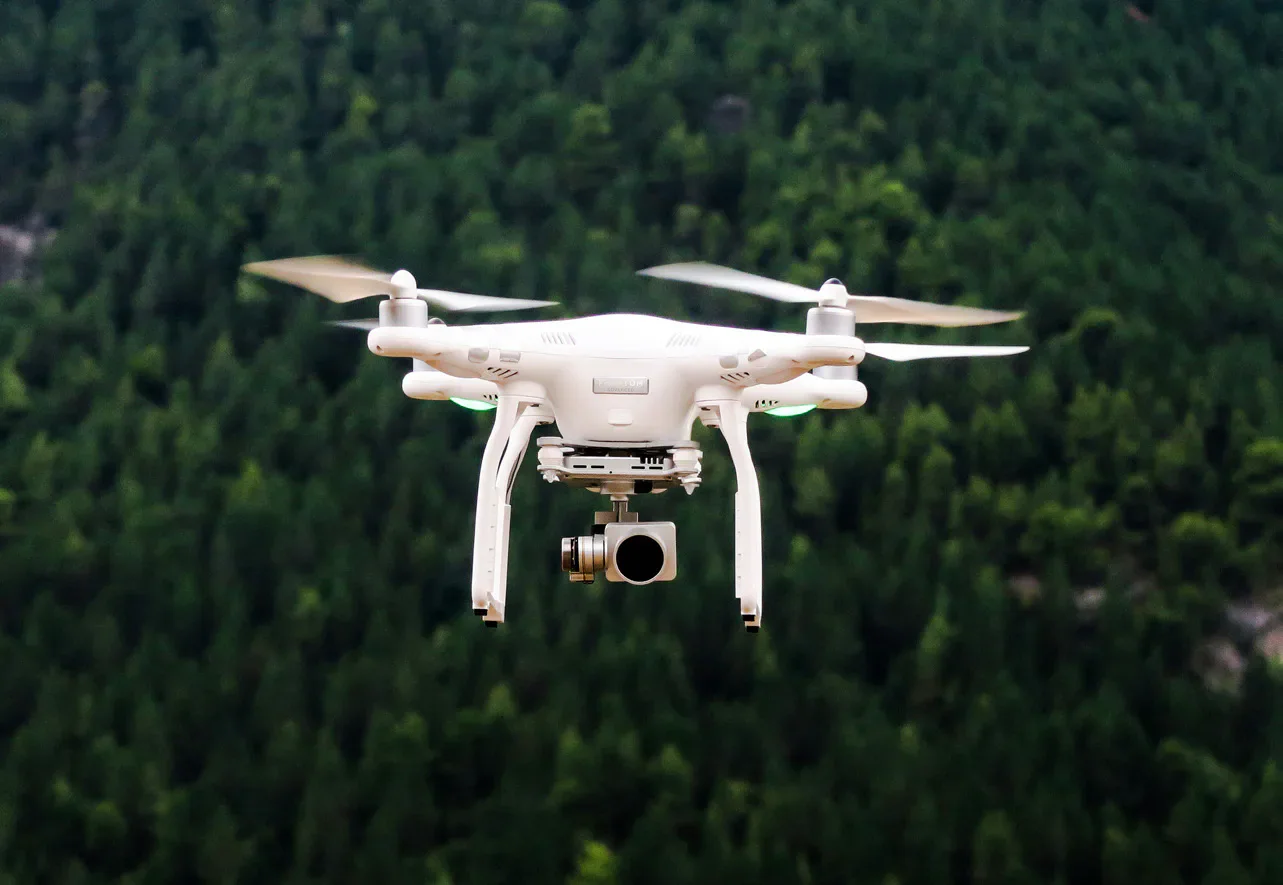 A white quadcopter drone in flight