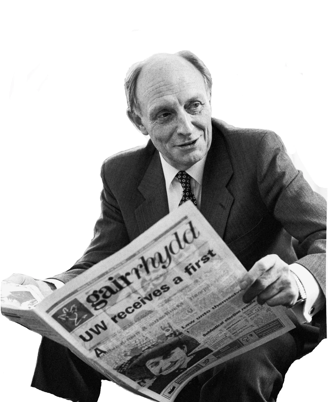 A historical photograph of Neil Kinnock holding a copy of Gair Rhydd.