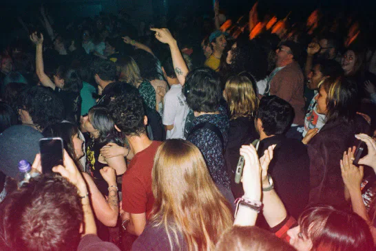 A packed audience dancing at a Los Campesinos! concert.