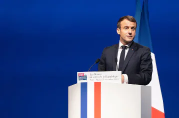 French president Emmanuel Macron speaking at a lectern.
