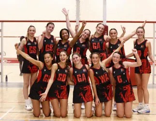 Cardiff University netball players posing together on court.