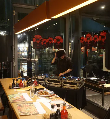 A DJ performing beside dining tables at Wagamama’s in Cardiff.
