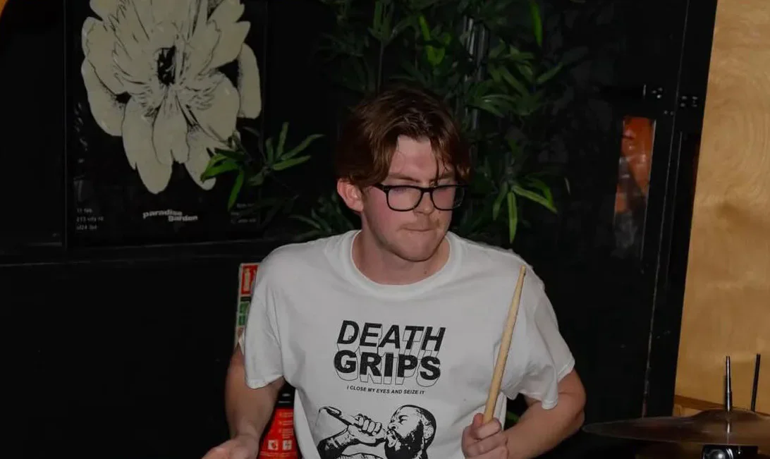 Member of Zero playing drums