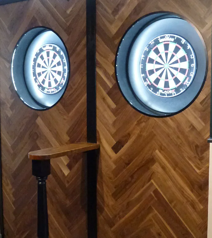 Two dartboards on a herringbone wall