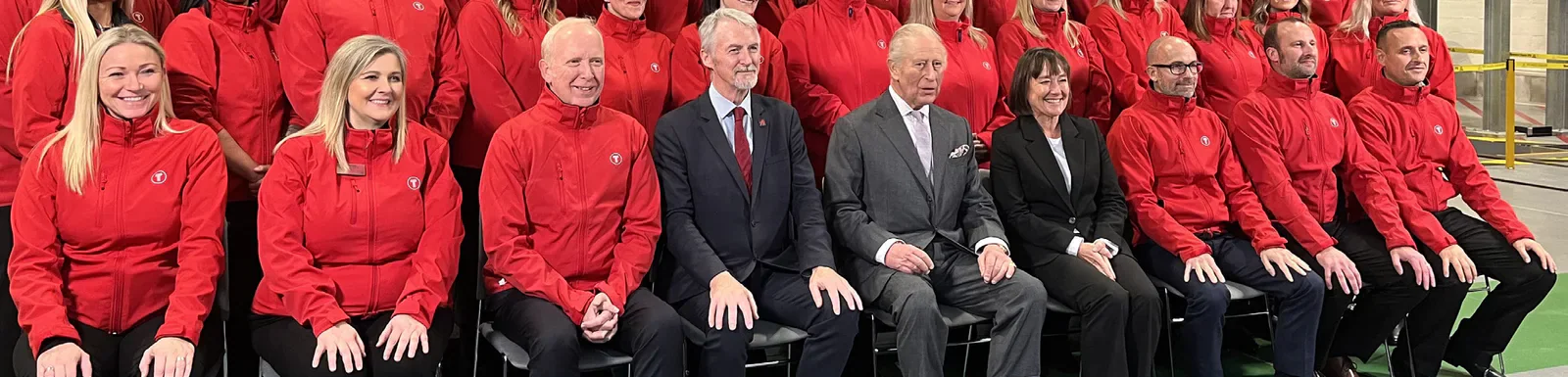 King Charles III seated with Transport for Wales staff at Taffs Well Depot