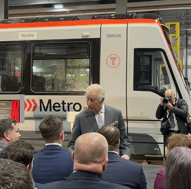 King Charles III speaking in front of a South Wales Metro tram-train