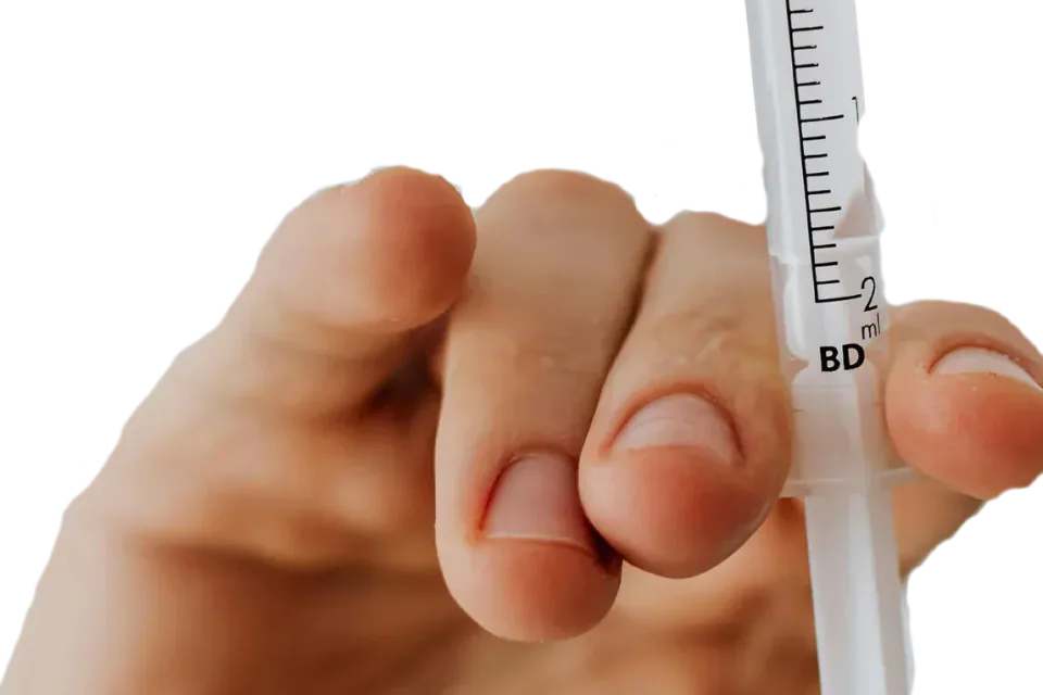 Hand holding a syringe