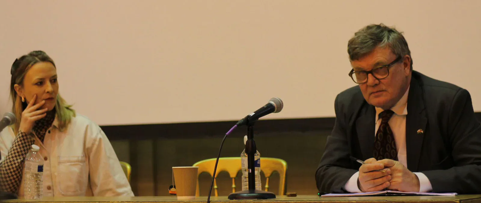 Peter Oborne seated at a panel table beside the event host.