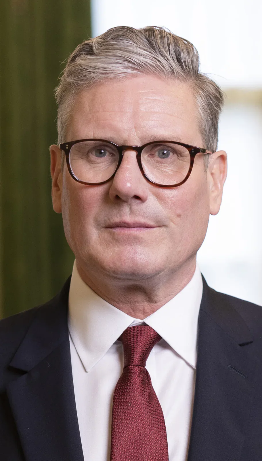 Portrait of Keir Starmer in a dark suit and red tie