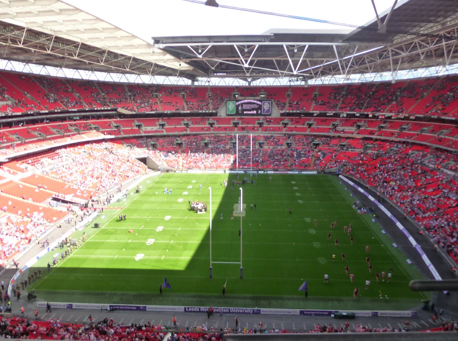 Rugby match inside a stadium with red seating