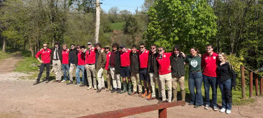 The shooting team poses for a group photograph outdoors.