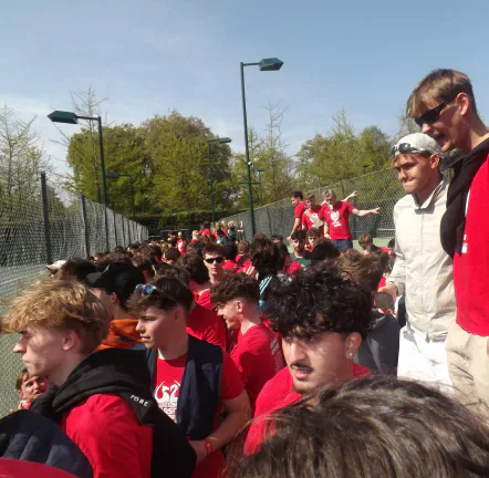 Cardiff supporters in red line the fence beside the tennis courts.