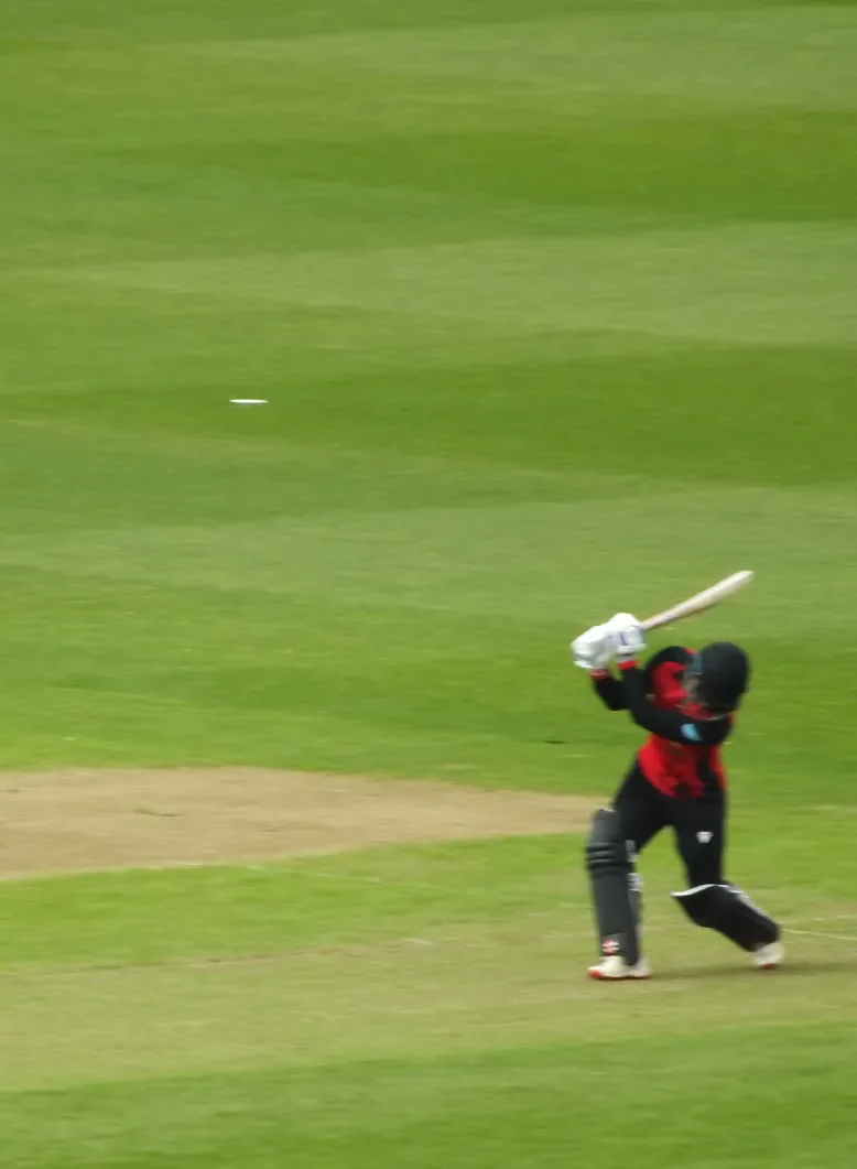 A Cardiff batter follows through after striking the ball.