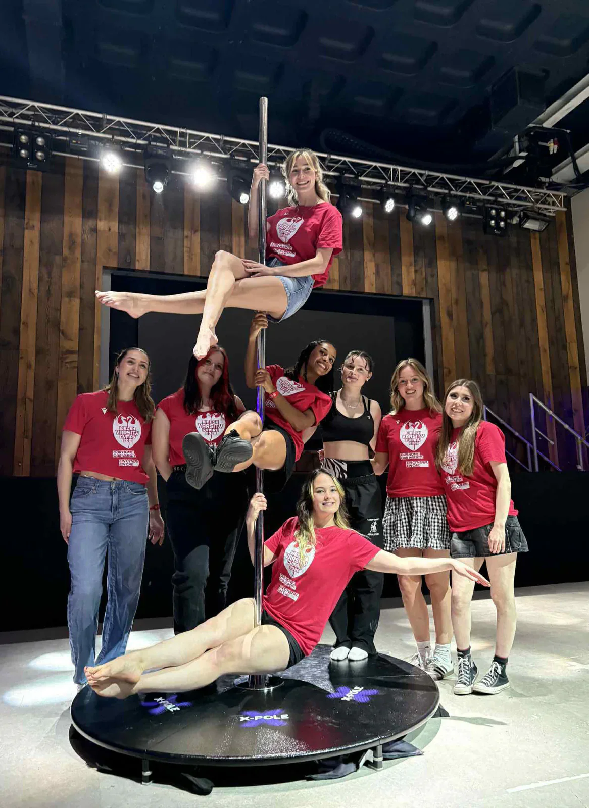 The aerial fitness team poses around a pole after the competition.