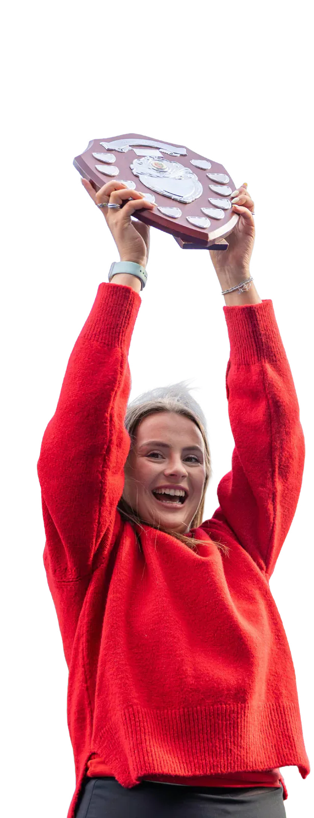 A supporter in a red jumper raises the Varsity shield.