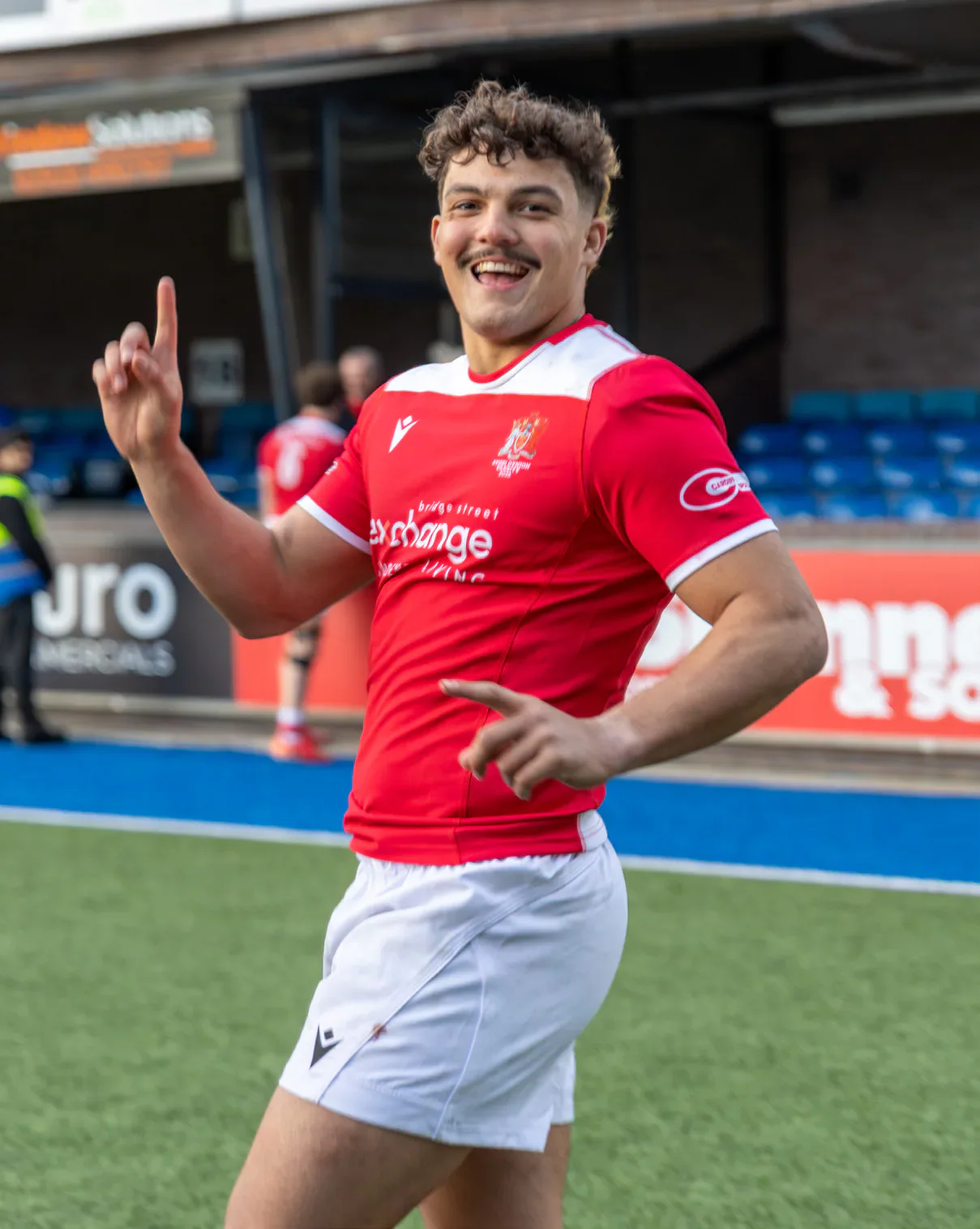 A Cardiff rugby player celebrates on the pitch.