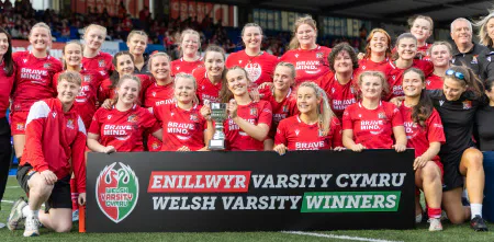The Cardiff women’s rugby team poses with the trophy and Welsh Varsity winners banner.