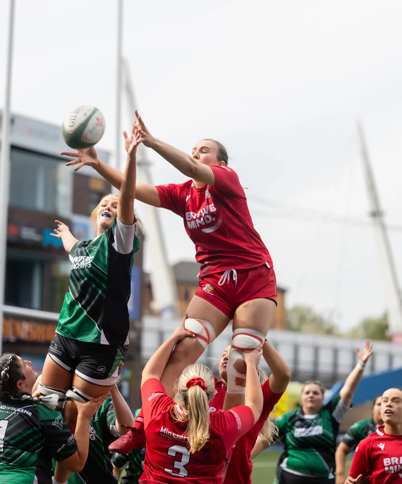 Cardiff and Swansea players compete for the ball at a rugby lineout.