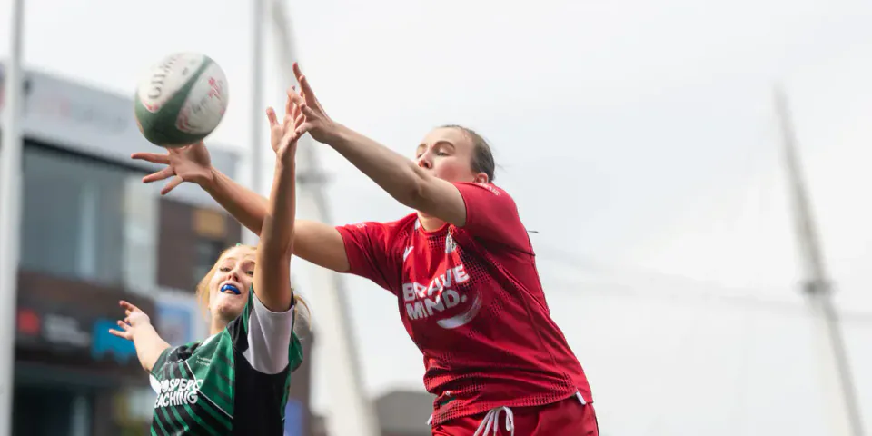 Cardiff and Swansea players compete for the ball at a rugby lineout.
