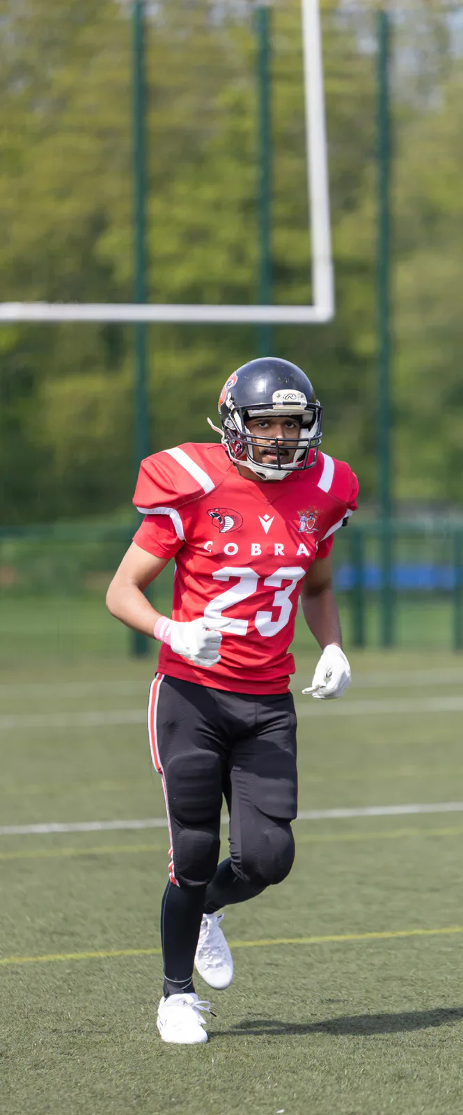 A Cardiff Cobras player runs beneath the goalposts.