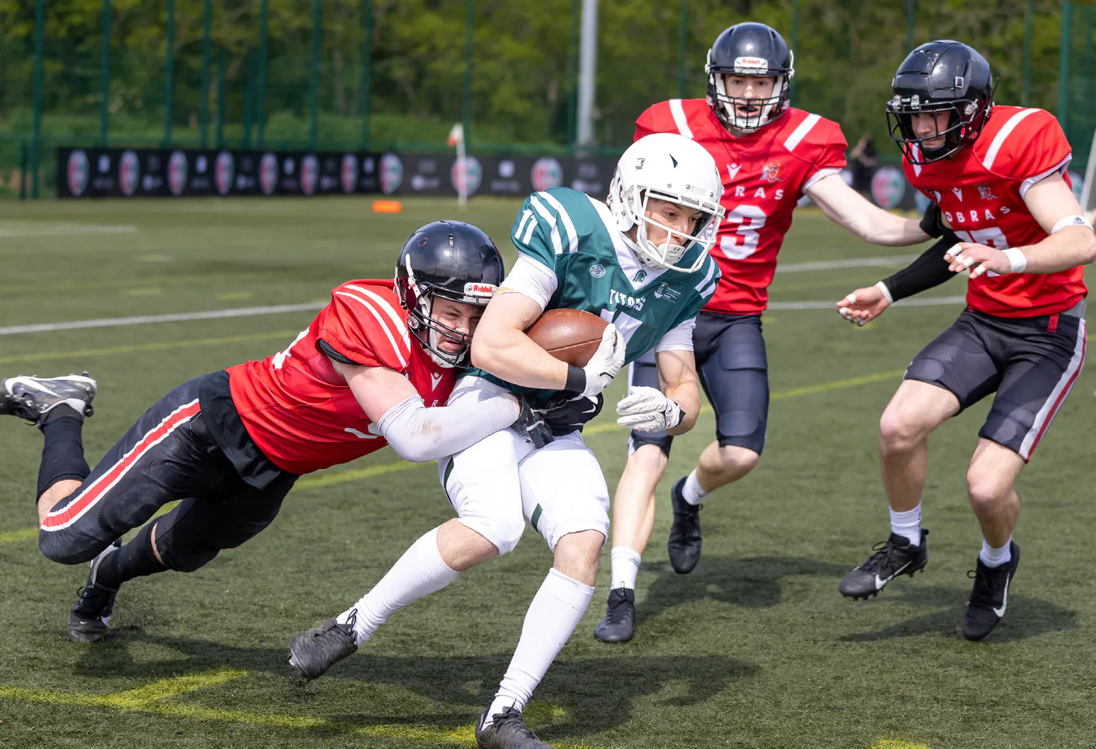 Cardiff Cobras defenders tackle a Swansea Titans ball carrier.