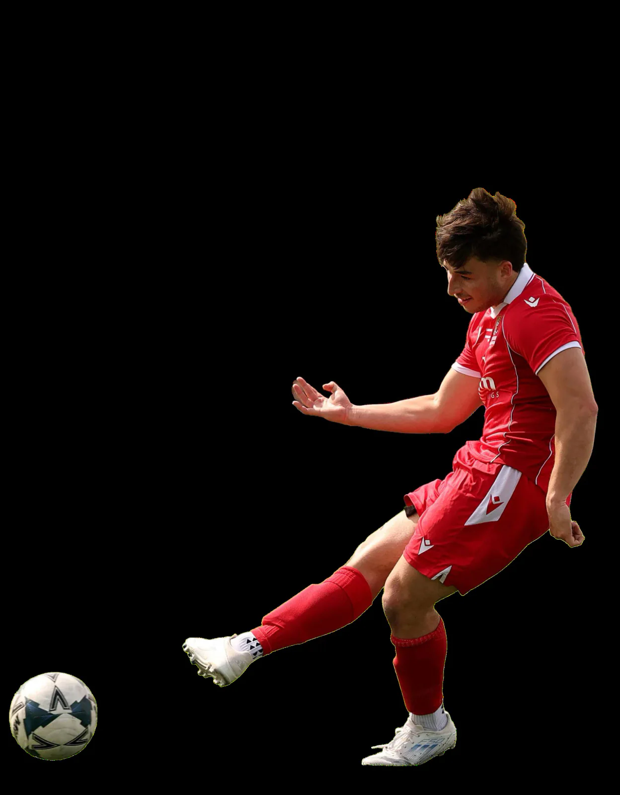 A Cardiff football player kicks the ball.