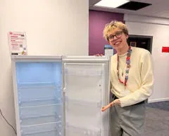 Josh Tandy standing beside a refrigerator.