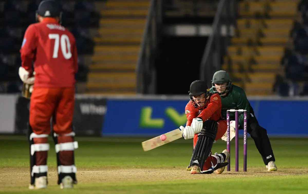 A Cardiff batter plays a shot with a Swansea wicketkeeper behind the stumps.